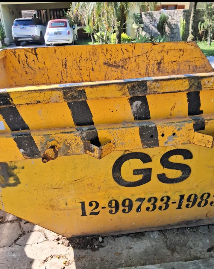 Detalhe da caçamba amarela da GS com identificação da empresa e telefone