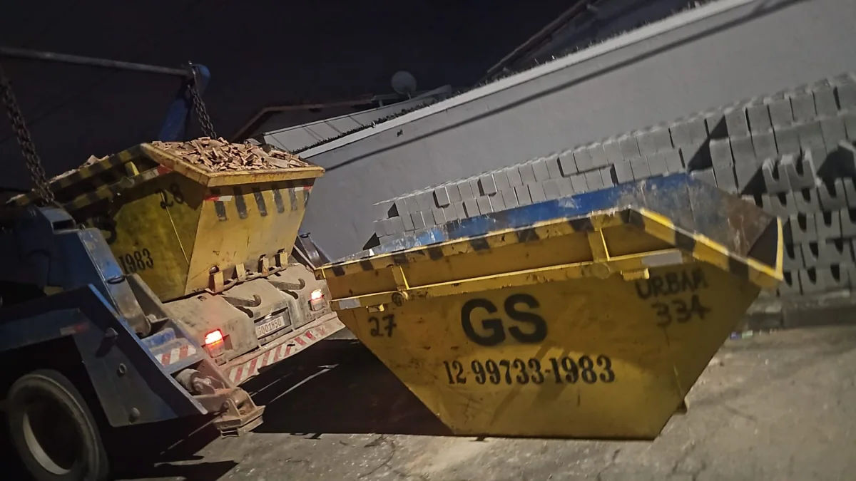 Caminhão da GS com duas caçambas amarelas em atendimento noturno
